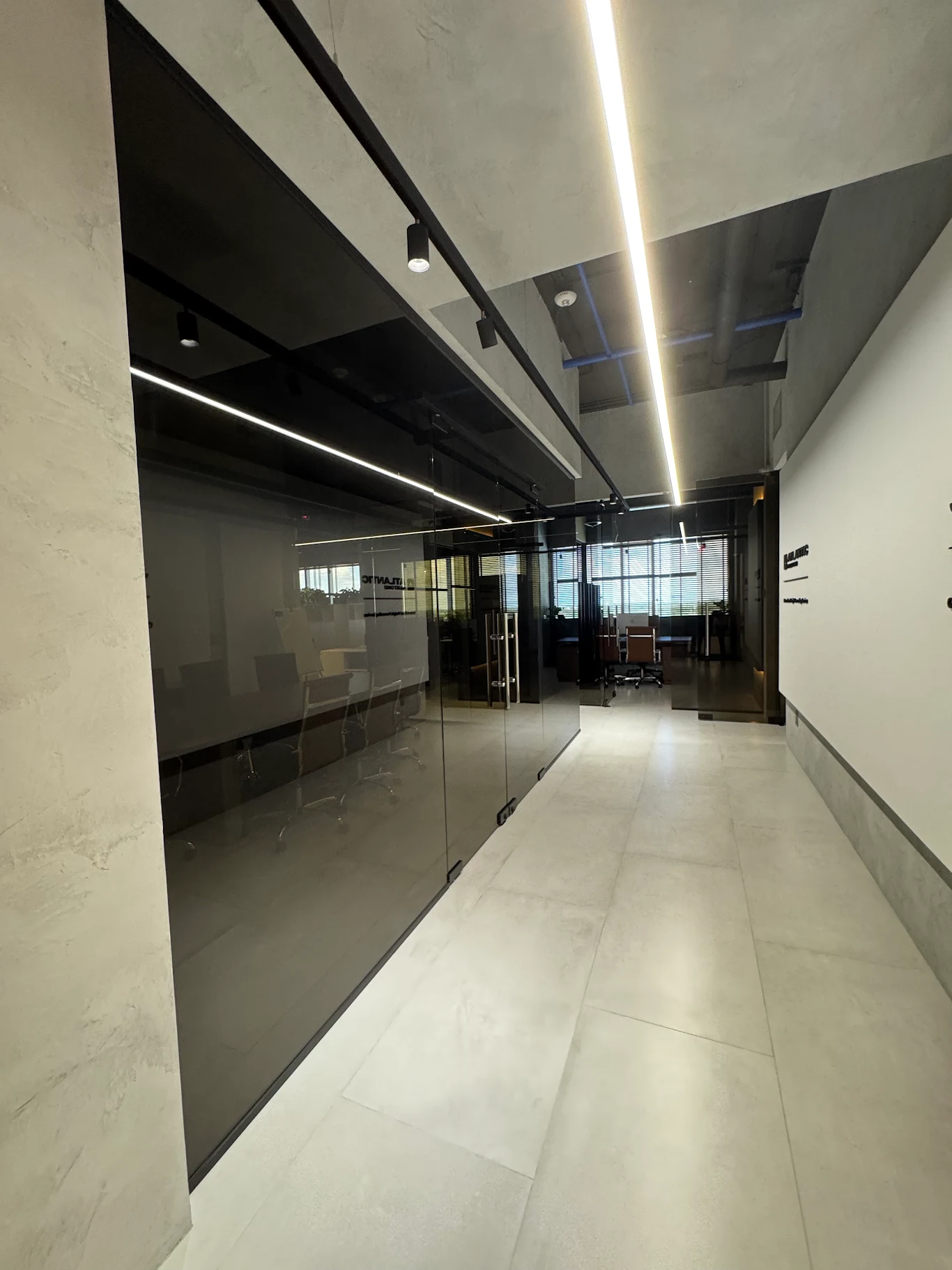 Office corridor with linear LED and black track lighting