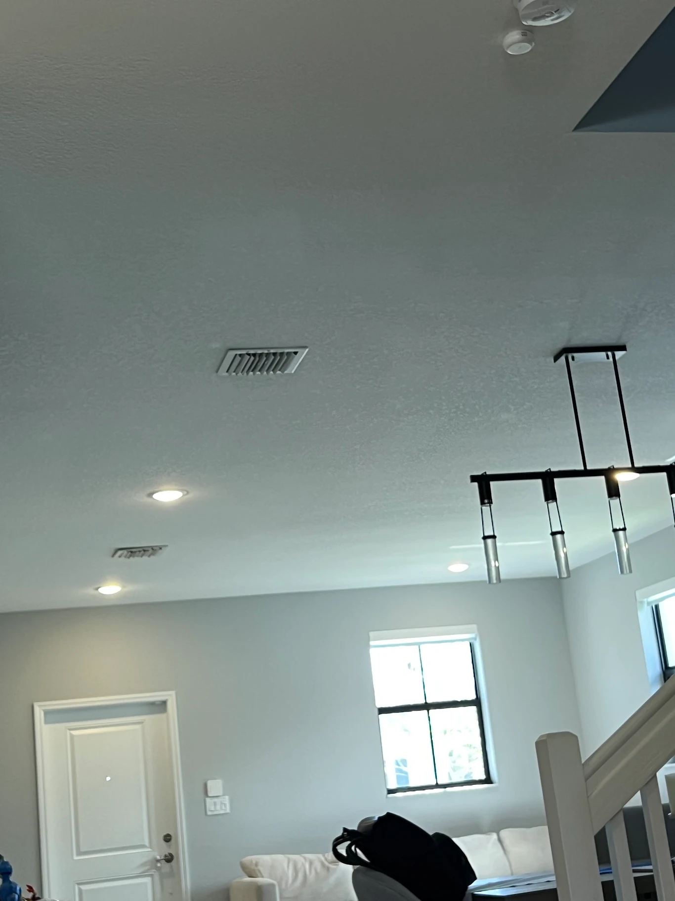 High-ceiling pot lights and a linear pendant fixture